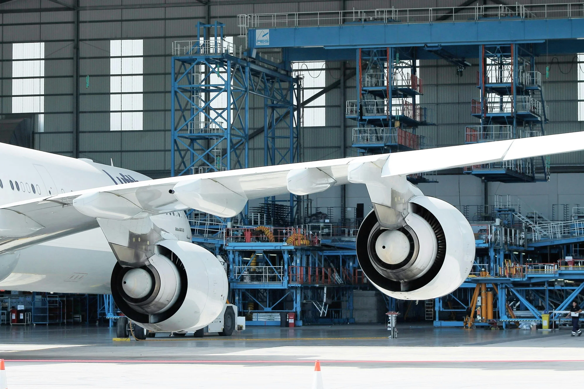 An Aviation Maintenance Technician inspecting a commercial airplane in a hangar needing repairs.