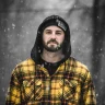 A CDL driver from Waco, Texas stands in the snow wearing a knit hat and hoodie during a snowstorm